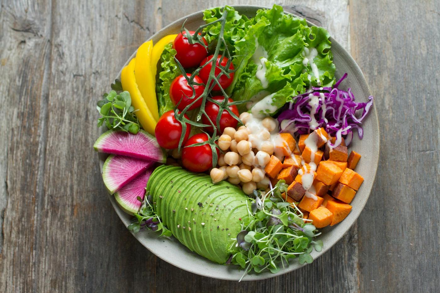 Bol de comida equilibrada con aguacate, garbanzos, tomate y verduras
